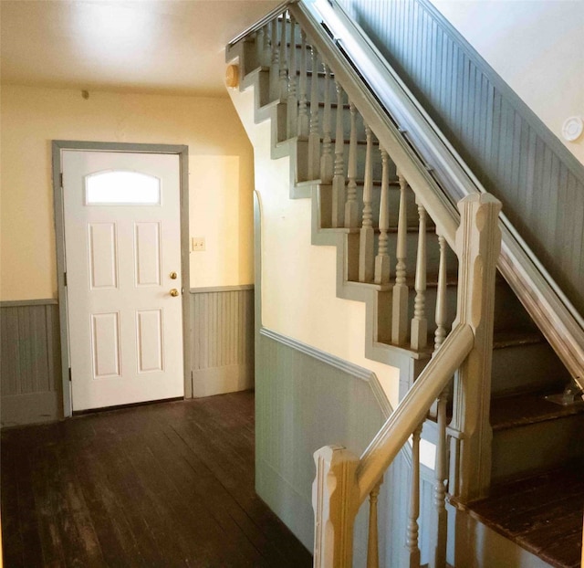 foyer entrance featuring wood-type flooring and wooden walls