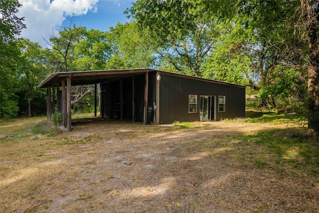 view of outdoor structure featuring a carport and driveway