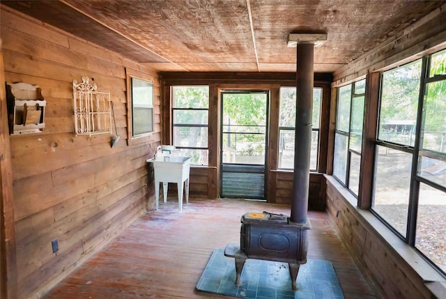 unfurnished sunroom featuring a wood stove