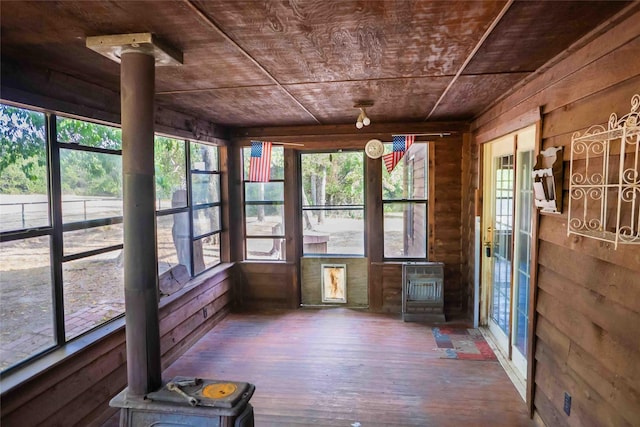unfurnished sunroom with a wealth of natural light, hardwood / wood-style floors, and wood walls