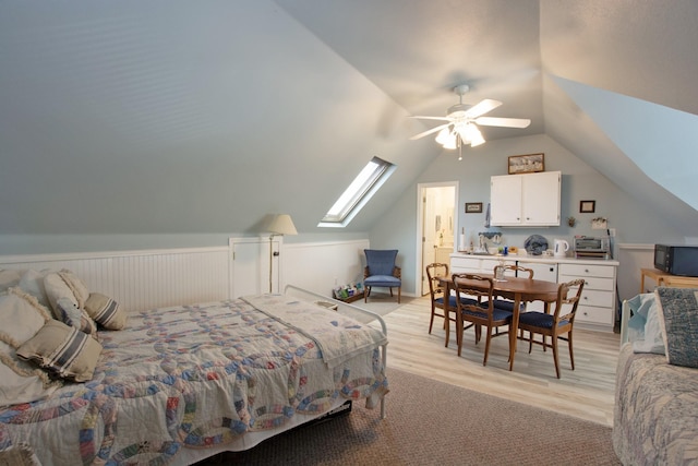 bedroom featuring lofted ceiling with skylight, ceiling fan, and light hardwood / wood-style floors