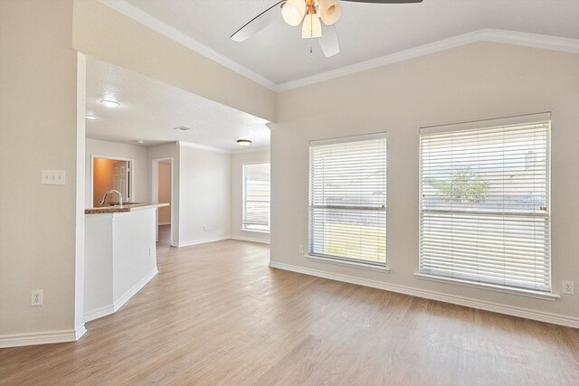 unfurnished living room featuring a textured ceiling, light hardwood / wood-style floors, crown molding, sink, and ceiling fan