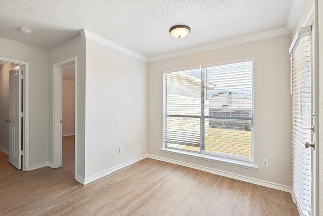 spare room with crown molding, a textured ceiling, and light hardwood / wood-style flooring