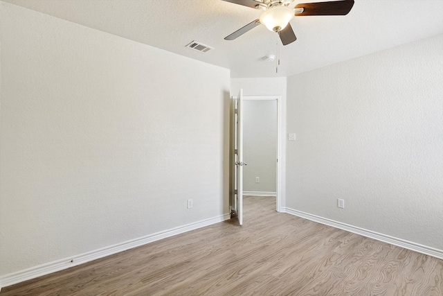 unfurnished room with a textured ceiling, light hardwood / wood-style flooring, and ceiling fan