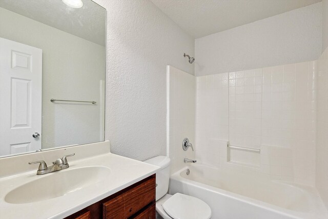 full bathroom featuring a textured ceiling, vanity, toilet, and shower / bathing tub combination