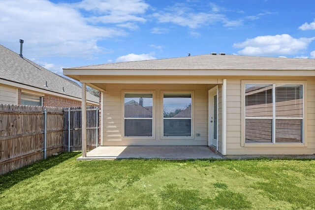 rear view of property featuring a yard and a patio area