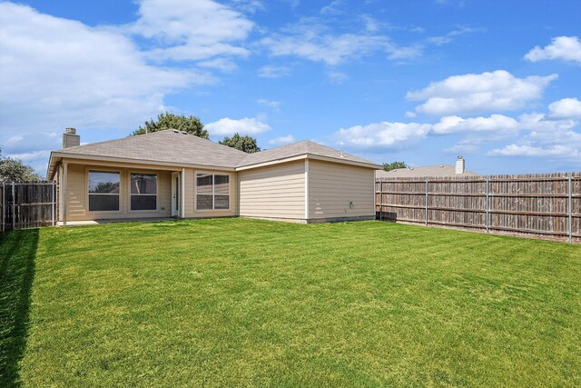 rear view of house featuring a yard