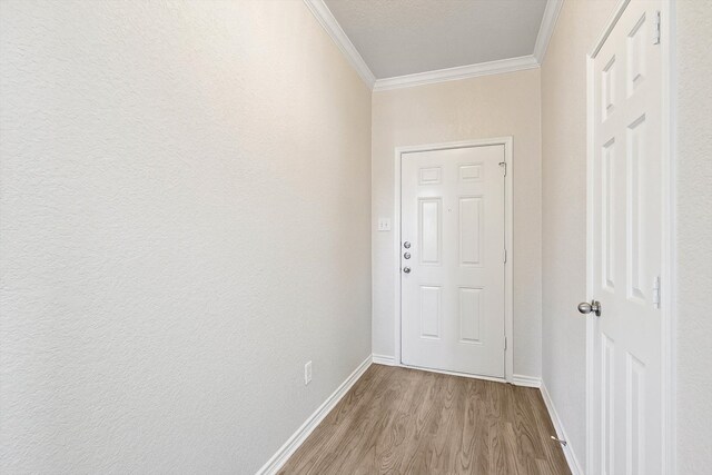 entryway with light hardwood / wood-style floors and ornamental molding