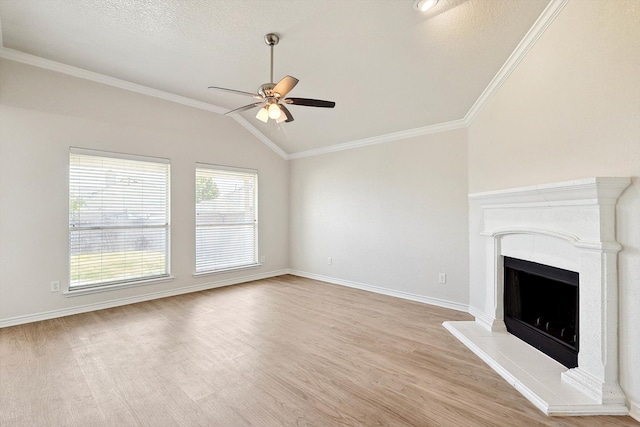 unfurnished living room featuring light wood-type flooring, ornamental molding, a textured ceiling, ceiling fan, and vaulted ceiling