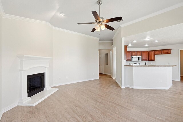 unfurnished living room with vaulted ceiling, light hardwood / wood-style floors, crown molding, sink, and ceiling fan