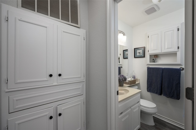 bathroom featuring vanity, hardwood / wood-style flooring, and toilet