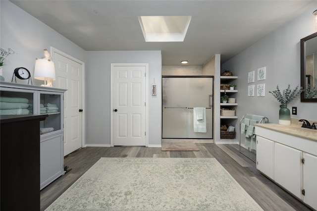 bathroom featuring hardwood / wood-style floors, vanity, and walk in shower