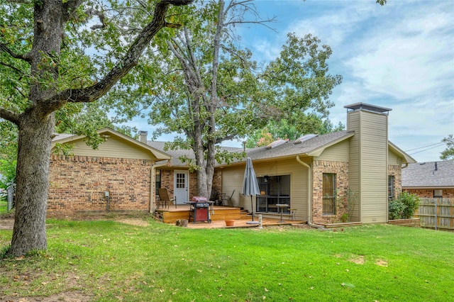 rear view of property featuring a lawn and a deck