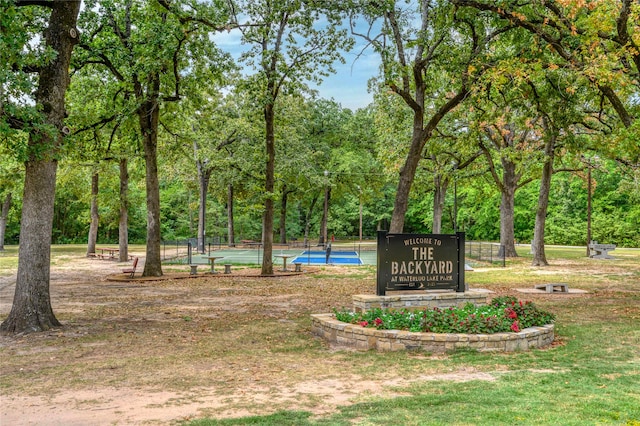 surrounding community featuring a lawn and tennis court