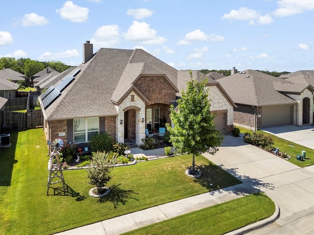 french country home featuring central AC, a garage, and a front lawn