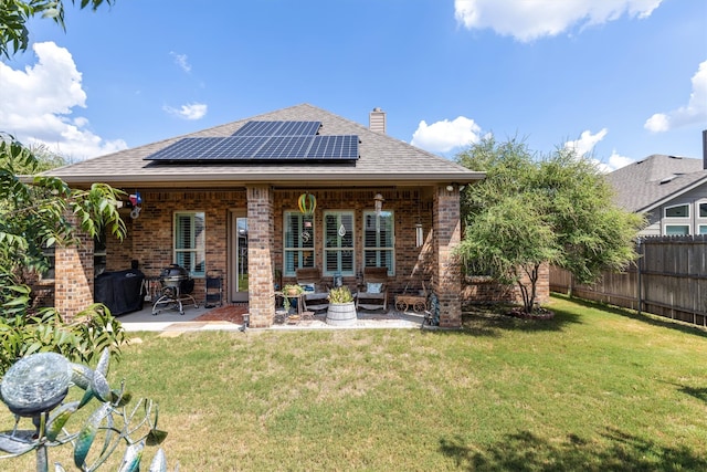 back of house with a yard, solar panels, and a patio