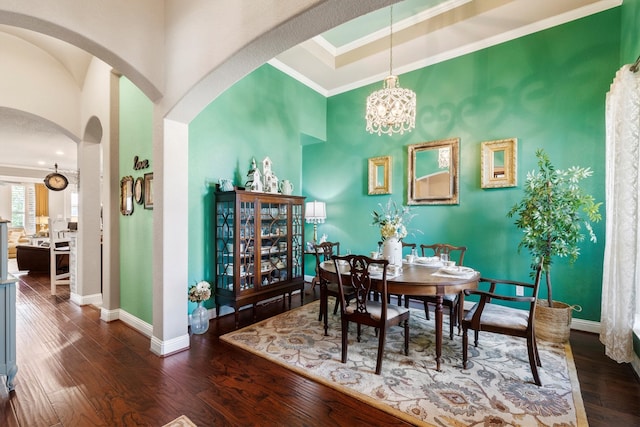 dining room with crown molding, dark hardwood / wood-style floors, and a notable chandelier