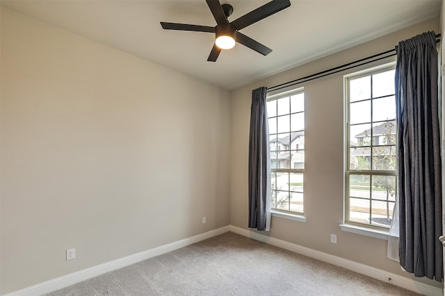 carpeted spare room featuring ceiling fan