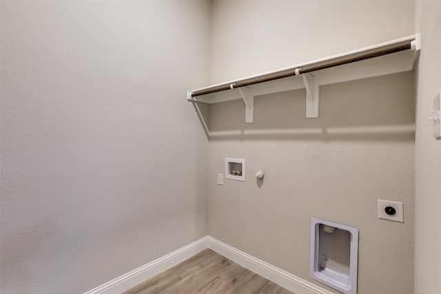 washroom with light wood-type flooring, hookup for a washing machine, electric dryer hookup, and hookup for a gas dryer