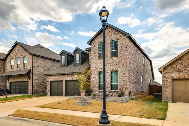 view of front of home with a garage, a front yard, and central air condition unit