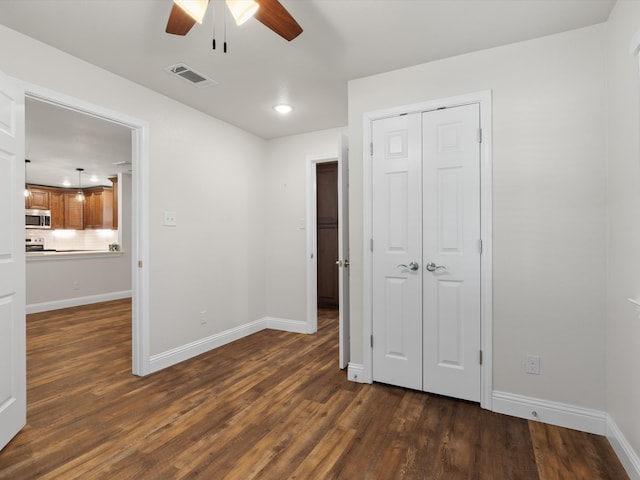 unfurnished bedroom featuring a closet, ceiling fan, and dark hardwood / wood-style floors