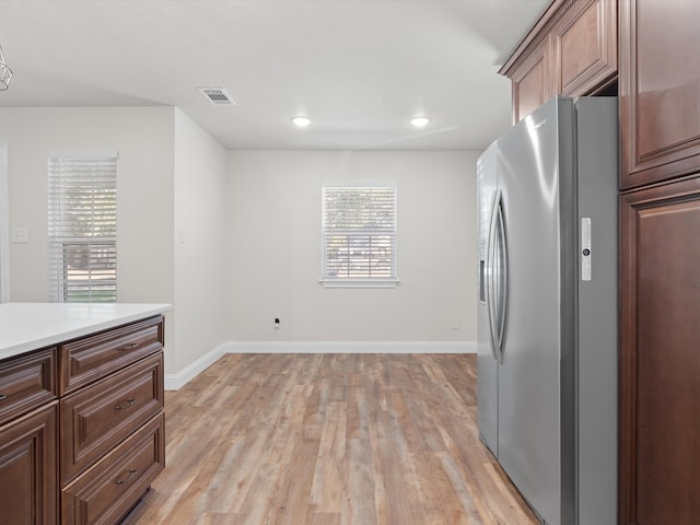 interior space with stainless steel refrigerator with ice dispenser and light wood-type flooring