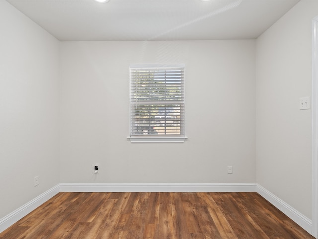 empty room with dark hardwood / wood-style flooring