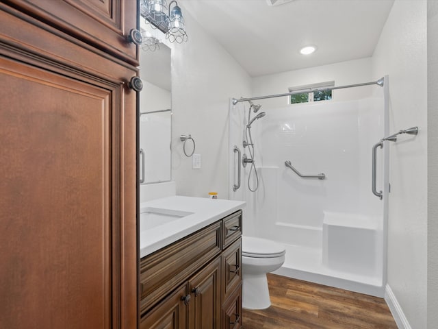 bathroom featuring walk in shower, toilet, wood-type flooring, and vanity