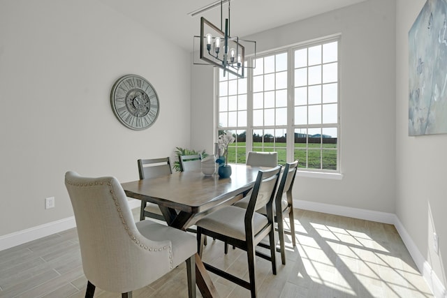 dining space featuring light wood-type flooring and an inviting chandelier