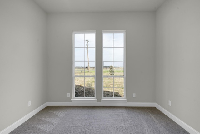 carpeted empty room with baseboards