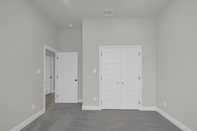 unfurnished bedroom with carpet floors, visible vents, and baseboards