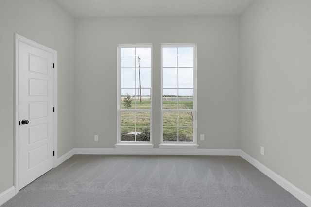 spare room featuring carpet flooring and baseboards