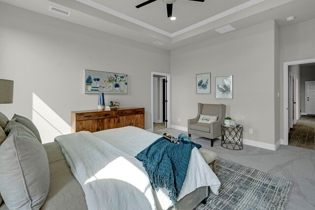 bedroom with carpet flooring, a tray ceiling, ceiling fan, and crown molding