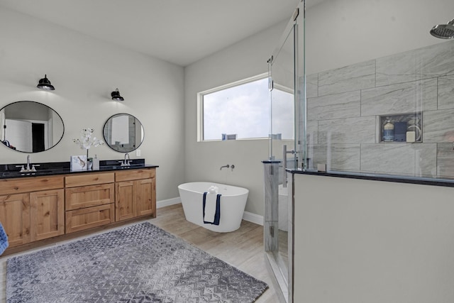 full bath with double vanity, a stall shower, a soaking tub, and a sink