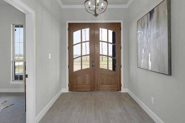 entryway featuring ornamental molding, french doors, baseboards, and an inviting chandelier