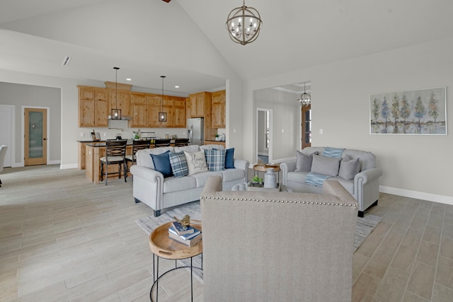 living room with a notable chandelier, high vaulted ceiling, and light hardwood / wood-style floors