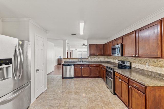 kitchen with decorative backsplash, dark countertops, appliances with stainless steel finishes, ornate columns, and a sink