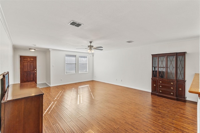 unfurnished living room with ornamental molding, light wood-type flooring, visible vents, and baseboards