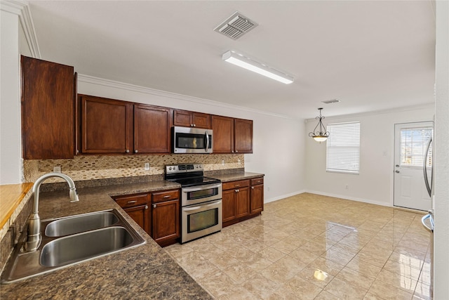 kitchen with a sink, visible vents, appliances with stainless steel finishes, tasteful backsplash, and dark countertops