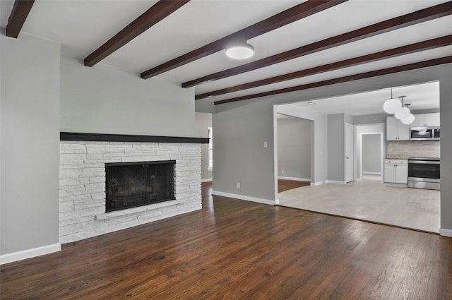 unfurnished living room featuring a fireplace, beamed ceiling, and hardwood / wood-style flooring