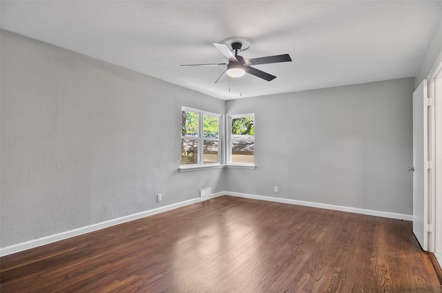 empty room with ceiling fan and dark hardwood / wood-style flooring