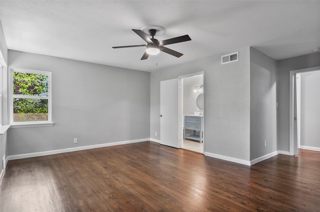 interior space featuring ceiling fan, a textured ceiling, dark hardwood / wood-style floors, and ensuite bathroom