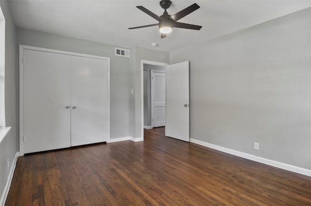 unfurnished bedroom with dark wood-type flooring, ceiling fan, and a closet