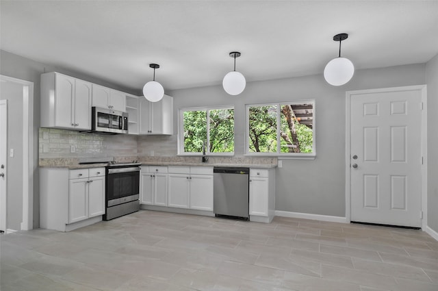 kitchen with white cabinets, backsplash, stainless steel appliances, and hanging light fixtures