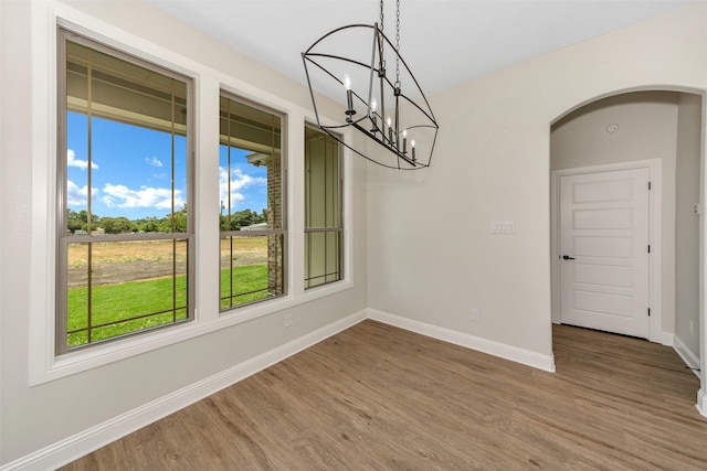 3043 Sunrise Trl, Weatherford, TX 76088 - unfurnished dining area with arched walkways, a chandelier, baseboards, and wood finished floors