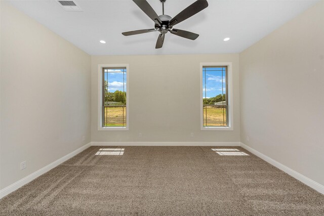 unfurnished room with carpet flooring, ceiling fan, and plenty of natural light