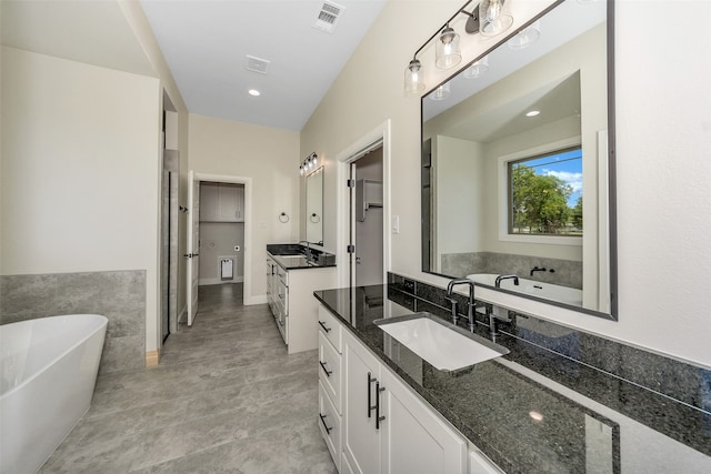 bathroom featuring a tub to relax in and vanity