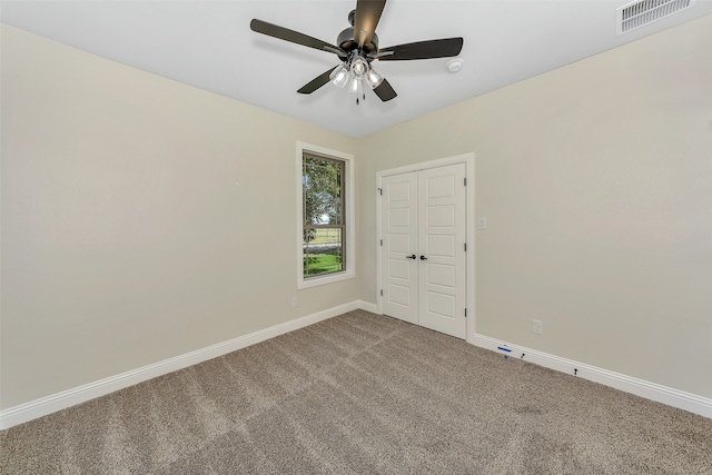 carpeted empty room featuring ceiling fan