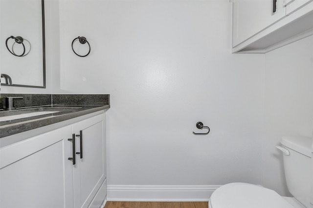 bathroom with hardwood / wood-style floors, toilet, and vanity