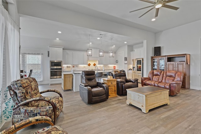 living room with ceiling fan, sink, and light hardwood / wood-style floors